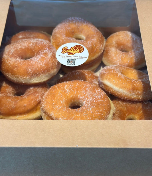 Box of sugared donuts with a Sally's Donuts label on a wooden surface
