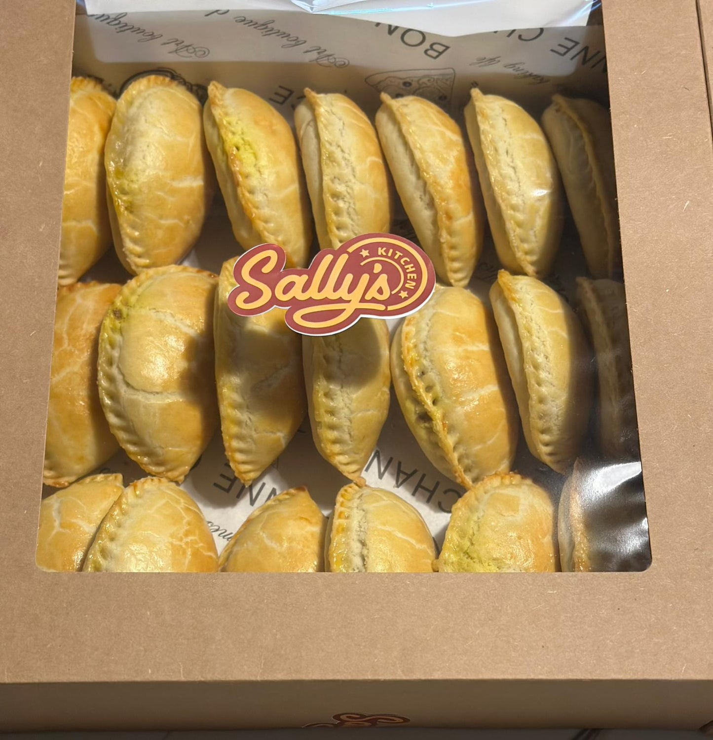 Box of meat pies with Sally's Kitchen logo on a brown background