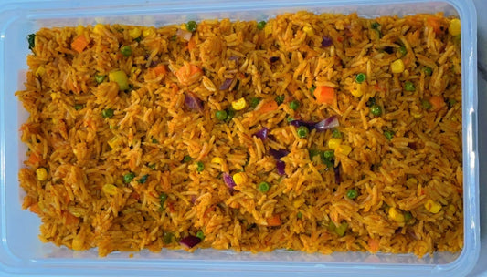 Container of yellow coconut rice with vegetables on a white background