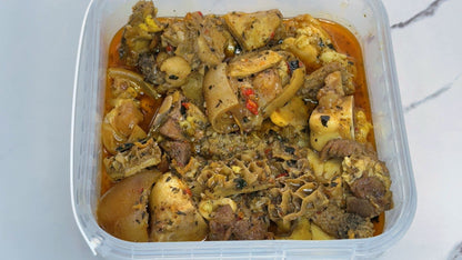 Container of goat meat pepper soup on a white background