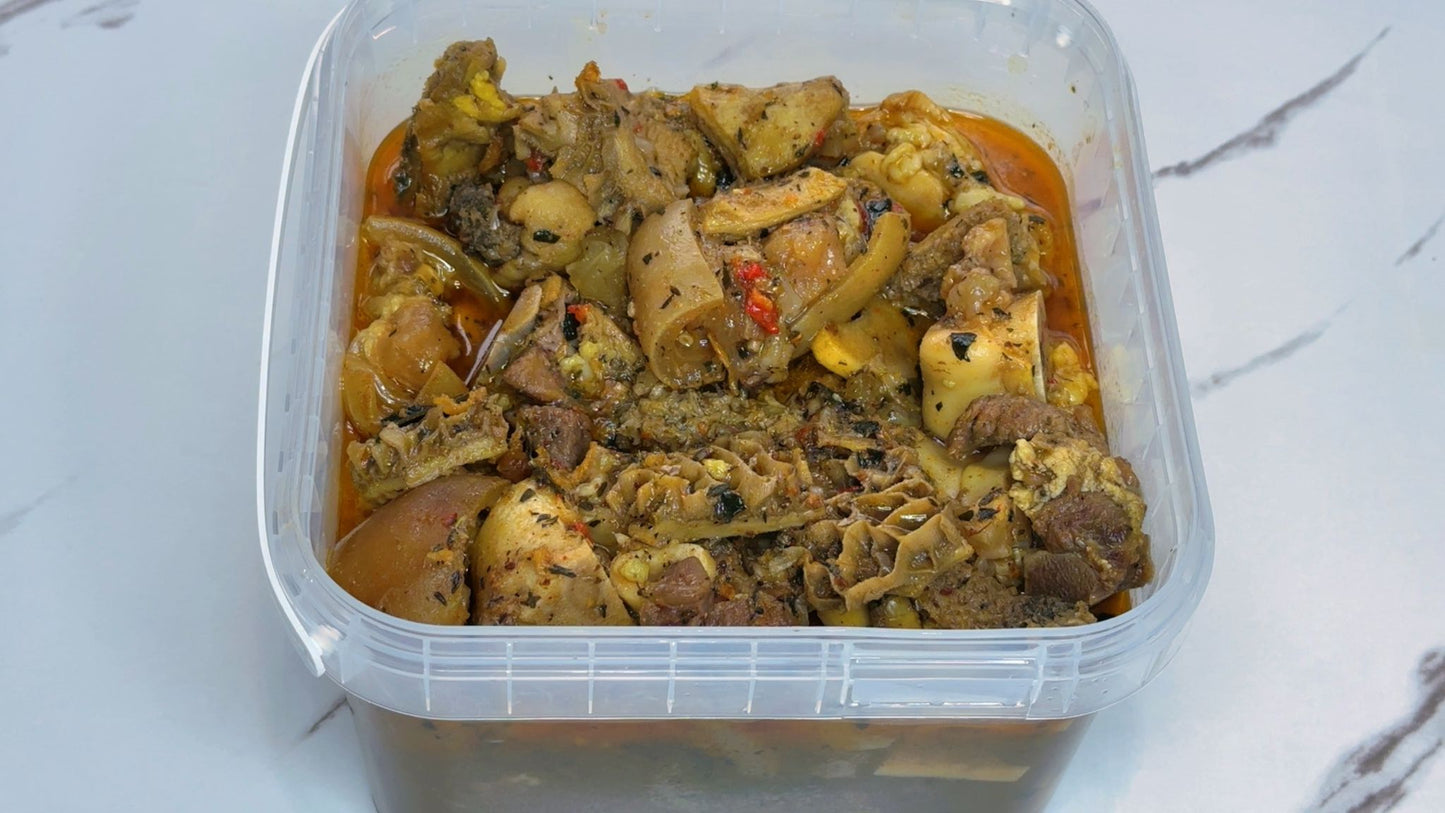 Container of Nigerian pepper soup on a white surface