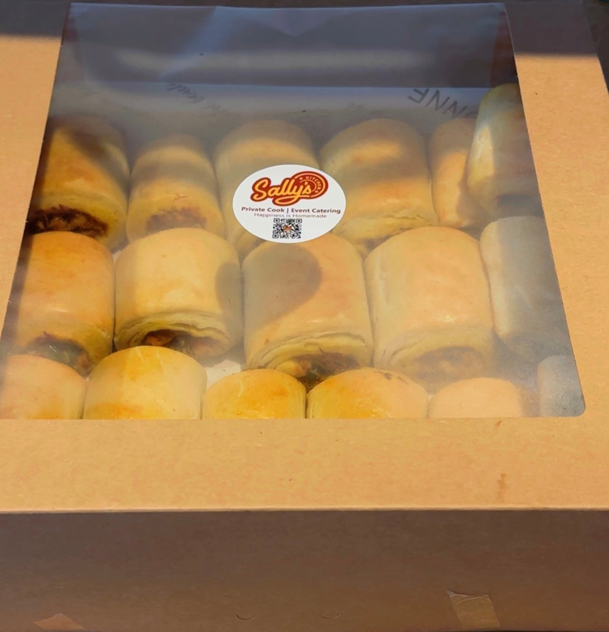 Box of pastries of Fish roll with a Sally's Bakery label on a clear window.