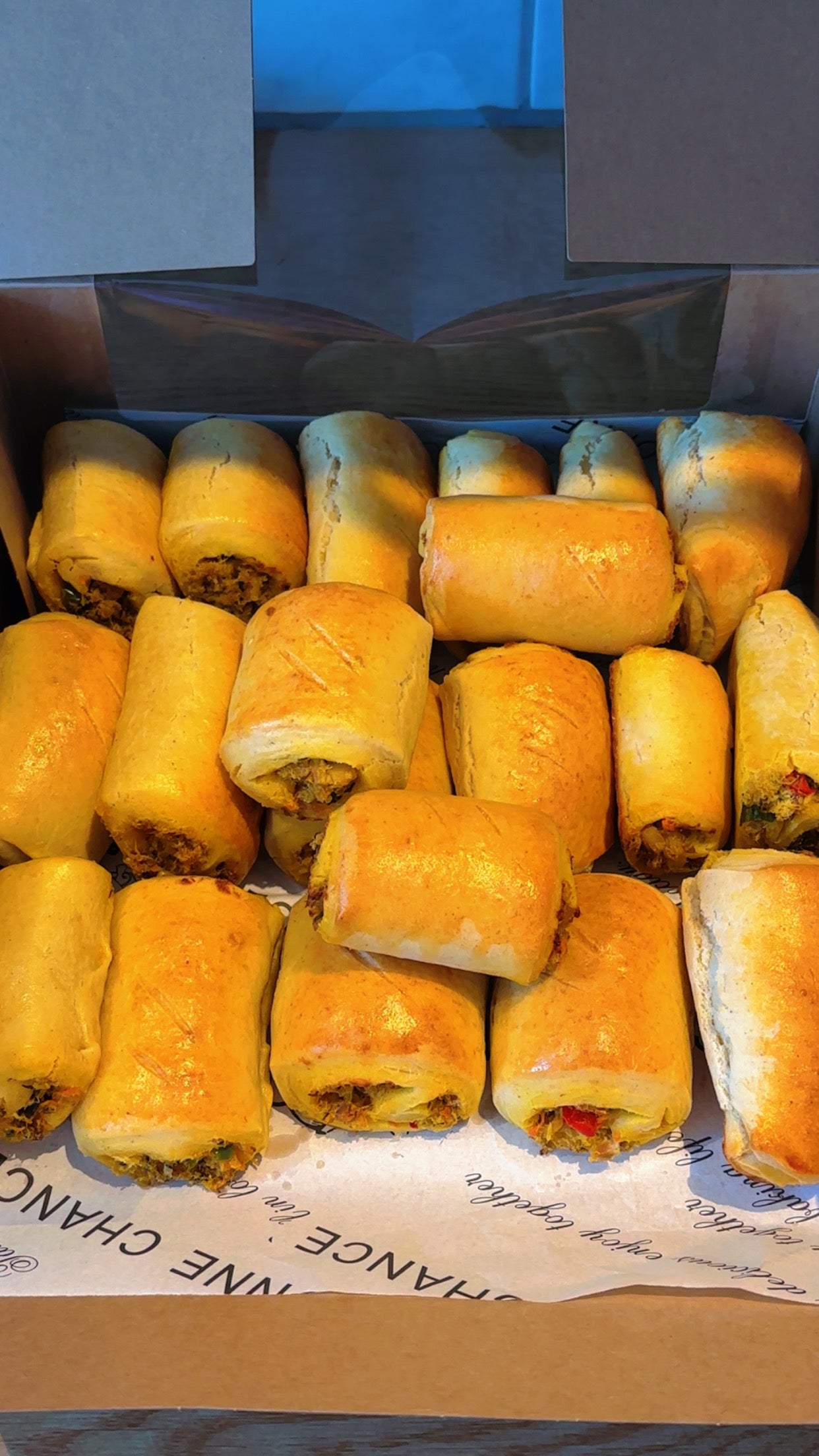 Box of golden-brown fish rolls with a visible brand name on the packaging.