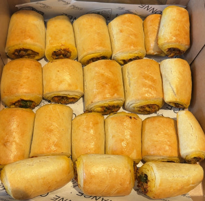 Box of golden-brown fish rolls on a white background